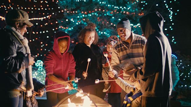 People gather around a fire in this promotional image from Denver Zoo, whose Zoo Lights festivities this year bring back popular features such as ice carving. (Provided by Denver Zoo)